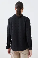 Camisa negra de manga larga con detalle de plumetti.