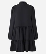 Vestido corto negro de chiffon con cuello alto, manga larga, volantes en la falda y cierre con botón en la espalda.