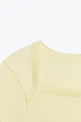 Camiseta color amarillo pálido, de corte slim fit, escote cuadrado y mangas cortas.