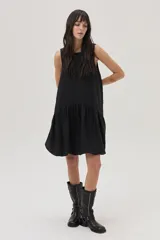 Vestido corto negro de lino, corte evasé, sin mangas y con escote redondo.