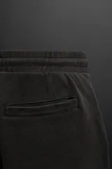 Bermuda jogger negra confeccionada en tejido de algodón con interior de rizo, cintura elástica ajustable con cordón y bolsillos laterales.
