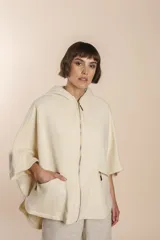 Capa color crudo de lana fina sin teñir, con capucha, cierre frontal y bolsillos con cierre.