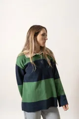Sweater verde y azul marino con cuello polo blanco y cierre parcial con botones.