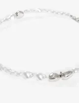 Collar corto de perlas irregulares color blanco con detalles de metal dorado y cierre de gancho.