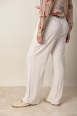 Pantalón ancho color beige de lino y rayón, con cintura elastizada ajustable con cordón y bolsillos laterales.