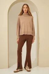 Sweater negro oversize de tejido de punto, con cuello alto y detalle de costuras a la vista.