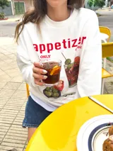 Buzo blanco de corte oversize con estampado de un trago y la frase "appetizer o'clock my only recipe w/ friends".