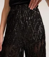 Pantalón pantalona de fiesta con cintura elástica y forro de short. Confeccionado en lentejuelas metalizadas con diseño geométrico.