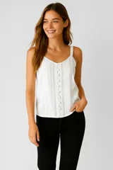 Musculosa blanca de bretel fino, cuello en V profundo y corte holgado.