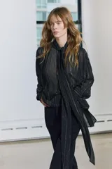Blusa negra con cuello redondo con lazo en el mismo tejido, manga larga con puño y detalle de hilo metalizado.