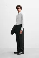 Camisa de vestir verde oscuro, corte slim fit, con cuello italiano, mangas largas con puños abotonados y cierre frontal con botones.