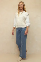 Pantalón de jean azul de tiro alto y corte ancho con dobladillo en el ruedo.