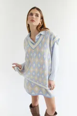 Chaleco tejido de lana con patrón de rombos en tonos lila, rojo y beige, con cuello en V y ribetes en color crema. Diseño oversize.