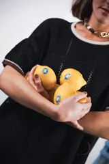 Vestido corto negro con patrón calado cuadrado, cuello redondo y mangas cortas con terminaciones a contratono en blanco.