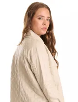 Chaqueta tipo camisa (shacket) de eco cuero color beige, con diseño acolchado en rombos, cuello camisero, botones frontales y dos bolsillos de parche en el pecho.