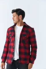 Sobrecamisa de algodón para hombre con interior de corderito, estampado a cuadros en tonos negro, blanco y azul. Tiene cierre de botones, bolsillos tipo cartera y logo en goma. El modelo usa talle M.