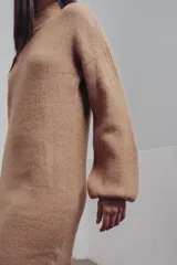 Vestido corto tejido de punto color fucsia, con cuello alto y mangas globo.