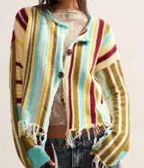 Saco tejido de punto con rayas verticales de colores: amarillo, celeste, verde, marrón y rojo. Tiene cuello redondo, cierre con botones y flecos en el ruedo.