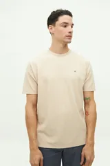 Remera color beige con textura, de manga corta, cuello redondo y logo estampado en el pecho.