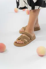 Sandalias planas color tostado, con doble tira ancha y diseño calado. Ajuste con abrojo.