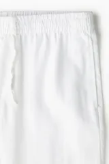 Pantalón blanco de lino liviano, corte recto, con elástico revestido y cordón ajustable en la cintura, bolsillos laterales y bolsillo trasero insertado.