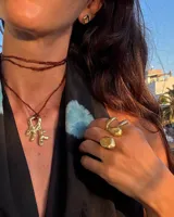 Par de aros dorados con forma cuadrada irregular y centro hueco.