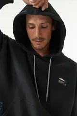 Canguro color crema con capucha ajustable, lettering estampado en el frente, logo en grifa de goma y puños.