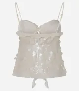 Blusa corta color crema, con lentejuelas y escote corazón. Tiene breteles finos ajustables, lazo en el busto y volados de chiffon.