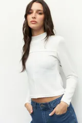 Polera negra de manga larga con cuello alto y costuras a la vista.