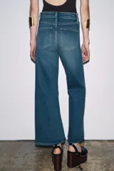 Pantalón de jean azul de corte ancho, tiro alto y largo hasta el tobillo.