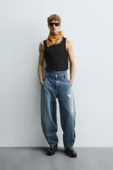 Musculosa blanca de algodón con cuello redondo y sisas amplias, corte ajustado.