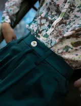 Pantalón palazzo de tiro alto color violeta, de satén. Tiene pretina delantera con pasadores, botón y cierre, pretina trasera elastizada y bolsillos verticales delanteros.