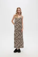 Vestido largo con estampado animal print en tonos beige y negro, breteles finos y corte holgado.