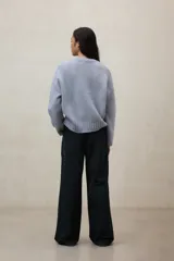 Sweater de punto grueso, color verde oliva, con cuello redondo y manga larga.