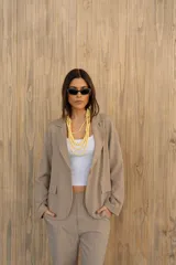 Blazer verde con rayas verticales blancas, solapas clásicas y corte entallado.