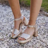 Sandalia de cuero color beige con diseño de tiras y tacón cuadrado.