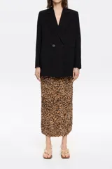 Falda midi de corte recto y ajustado, con estampado animal print en tonos marrones y negros. Presenta goma elástica en la cintura y abertura trasera en el bajo.