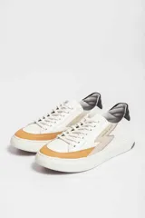 Zapatillas deportivas color verde militar con detalles en negro y beige. Presentan cordones negros, suela blanca y un rayo beige en el lateral.