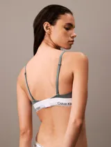 Conjunto de ropa interior Calvin Klein, modelo Modern Cotton, color gris, compuesto por un corpiño triangular con breteles finos regulables y una bombacha tipo tanga. Ambos con banda elástica blanca con logo de la marca.
