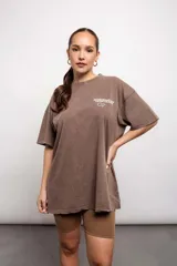 Remera marrón de corte holgado con estampado frontal de texto.