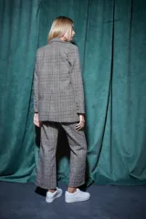 Conjunto sastrero a cuadros grises, compuesto por un blazer de corte clásico y un pantalón palazzo.