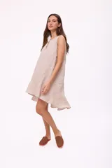 Vestido corto sin mangas de color rojo, con cuello redondo y detalle de abertura tipo gota en el pecho. Presenta un diseño holgado y terminación con volado en el ruedo.