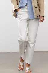 Pantalón de jean color crudo, de tiro medio, corte tapered, con cinco bolsillos y raya planchada en el frente.