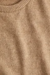 Buzo color beige de punto fino suave con cuello redondo y mangas cortas.