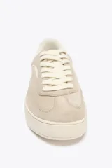 Zapatillas deportivas color beige, estilo soft, con cuerpo en combinación de materiales y cierre mediante cordones. Suela de 3 cm de altura.