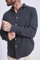 Camisa de manga larga color gris oscuro, con cuello clásico y cierre frontal con botones.