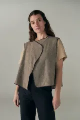 Chaleco marrón con solapas amplias y terminaciones envivadas. Diseño reversible y sin mangas.