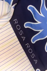 Pareo rectangular de viscosa con estampado de flores rojas sobre fondo borgoña y borde inferior con rayas verticales rojas, amarillas y blancas.