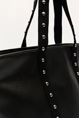 Bolso shopper de símil cuero color beige, con asas largas decoradas con tachas metálicas.