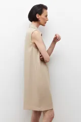 Vestido negro sin mangas con cuello camisero y cierre frontal con cordones. Presenta dos bolsillos con solapa a la altura del pecho y dos bolsillos laterales a la altura de la cadera.